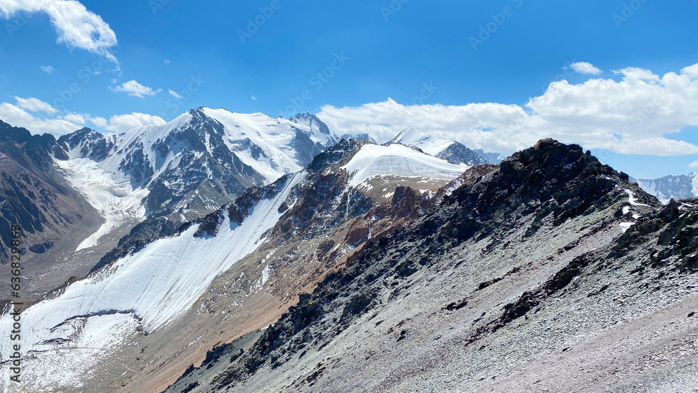 Fototapeta premium Snow-capped mountain peaks. Beautiful mountain summer landscape. Amazing mountain view around Komsomolets Peak, Ala-Archa National Park, Kyrgyzstan.