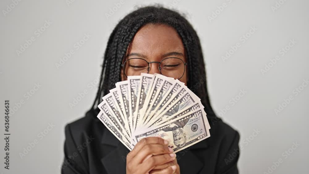 African american woman business worker covering mouth with dollars over isolated white background African american woman business worker covering mouth with dollars over isolated white background