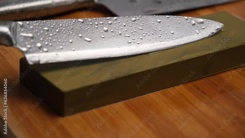 Sharpening knives with a Whetstone. Knife sharpening. Sharp knife and sharpening stone on a wooden cutting board. Sharpening knives with a Whetstone. Knife sharpening. Sharp knife and sharpening stone on a wooden cutting board.