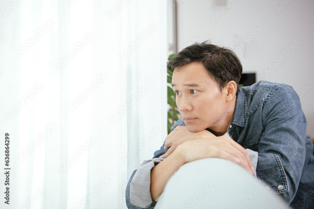 Asian guy are looking  to outside the window