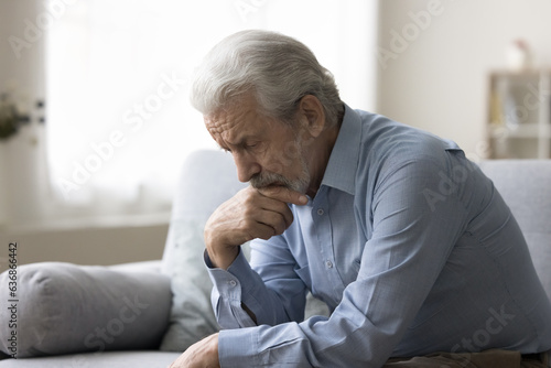 Sad lonely grey haired old man thinking on geriatric health problems, bored retirement at home, feeling sick, tired, suffering from depression, memory loss, mental disorder