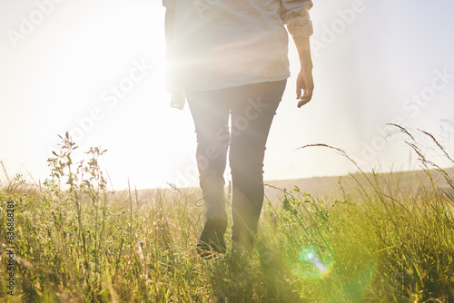 Back, sunrise and a woman walking on a farm for sustainability or growth in the morning with flare. Farming, agriculture and female farmer on a nature landscape for eco friendly harvesting in season