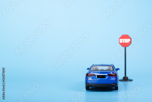 Obraz na płótnie driver education, car at stop road sign on blue background, car accident prevent