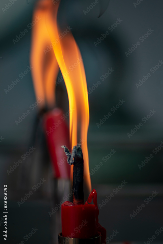 Naklejka premium Red candles are lit for worship and blurred background.