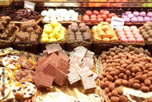 French macarons and other sweets on counter of market