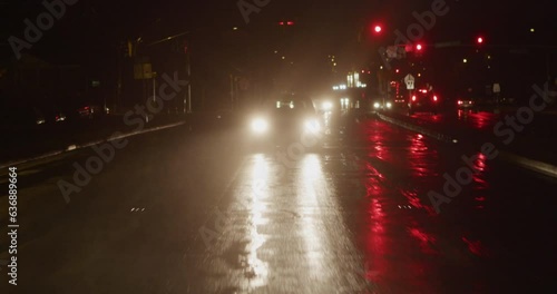 Cars driving towards the camera at night in the rain 2