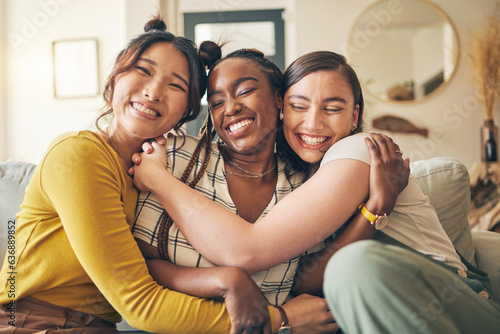 Portrait of a group of women, friends hug on sofa with smile and bonding in living room together in embrace. Hug, love and friendship, girls on couch with diversity, pride and people in home with fun photo