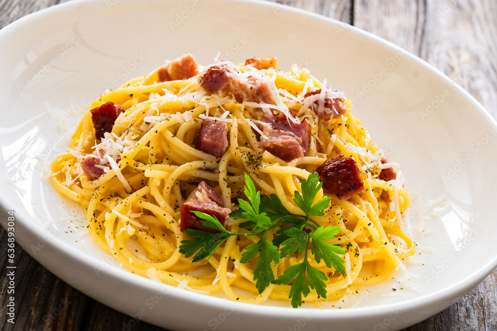 Spaghetti carbonara on wooden table
