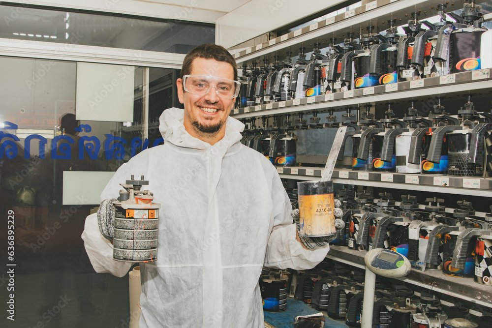 Professional painters mix car paint formulas in the paint storage room