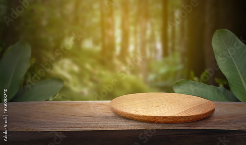 Empty wooden plate on wood table. Soft blurry background, of free space for your copy and branding. Use as products display montage. Vintage style concept.