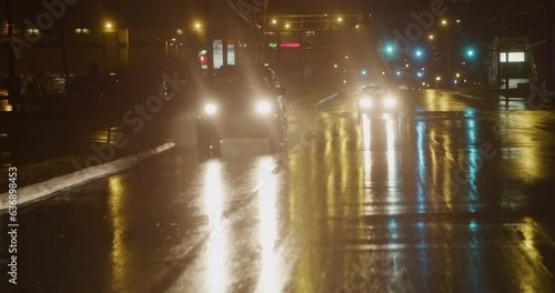 Cars driving towards the camera at night in the rain 4