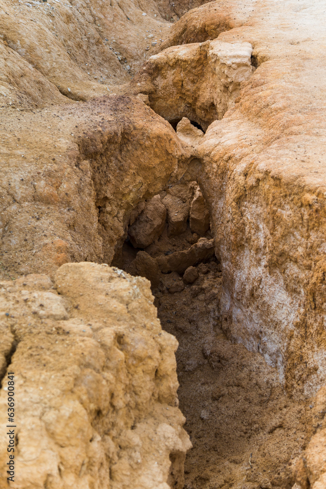 Obraz premium A deep crack in the mountain, a crack the clay earth. Abandoned clay quarry.
