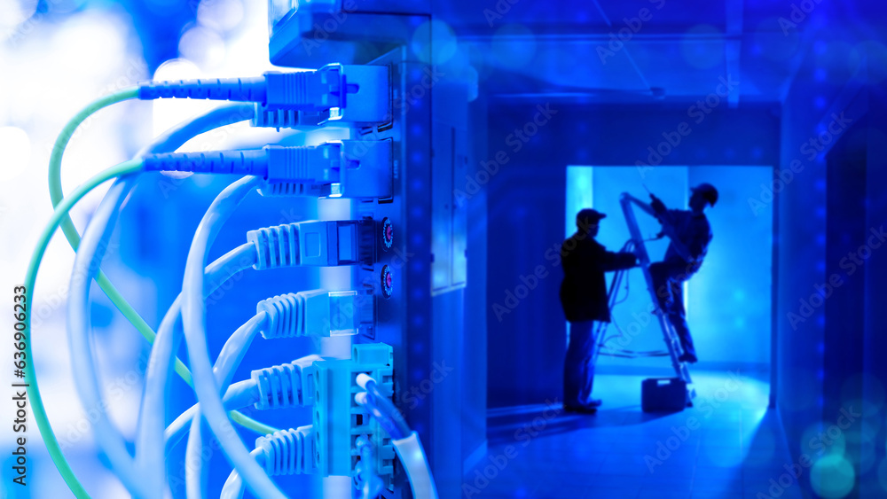 Network hardware. Wires are connected to equipment. Workers