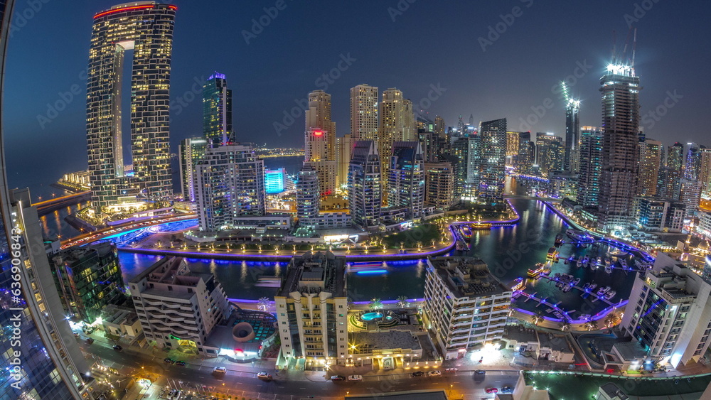 Panoramic view of Dubai Marina with several boat and yachts parked in harbor and skyscrapers around canal aerial day to night timelapse.