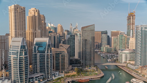 Dubai Marina with several boat and yachts parked in harbor and skyscrapers around canal aerial timelapse. © neiezhmakov