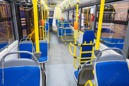 City bus interior. Public transport. Modern trolleybus view inside. New bus with seats for disabled. Tram interior without passengers. Bus with yellow handrails. Modern public transport