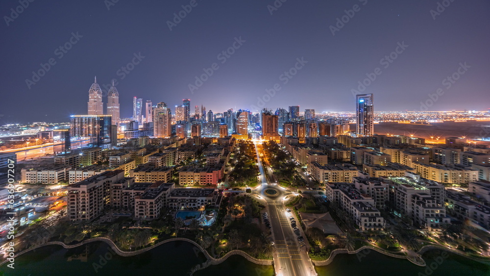 Panorama of skyscrapers in Barsha Heights district and low rise buildings in Greens district aerial all night timelapse.