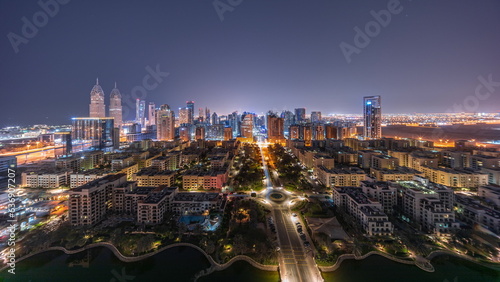 Panorama of skyscrapers in Barsha Heights district and low rise buildings in Greens district aerial all night timelapse.