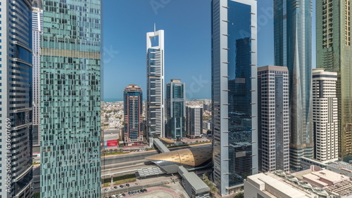 Panorama showing aerial view of Dubai International Financial District with many skyscrapers timelapse.