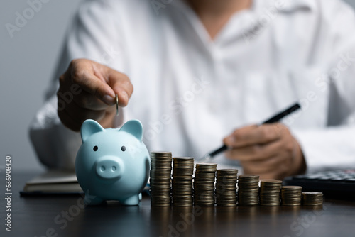 woman hand putting money coin into piggy for saving money wealth and financial concept.