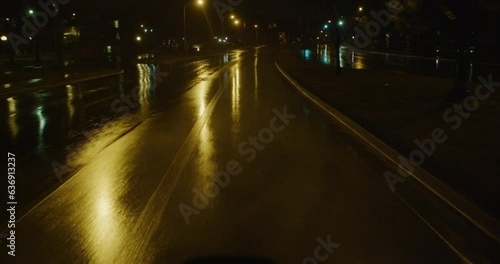 Driving along empty city street in the rain at night 3