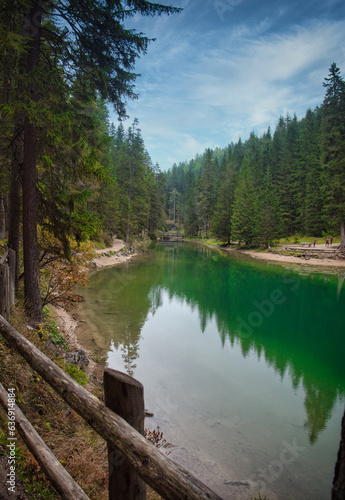 Photo of a tranquil lake nestled among the lush greenery of the Italian Dolomites
