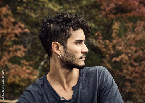 Photo of a stylish man with curly hair wearing a black shirt against the stunning backdrop of the Dolomites in Italy