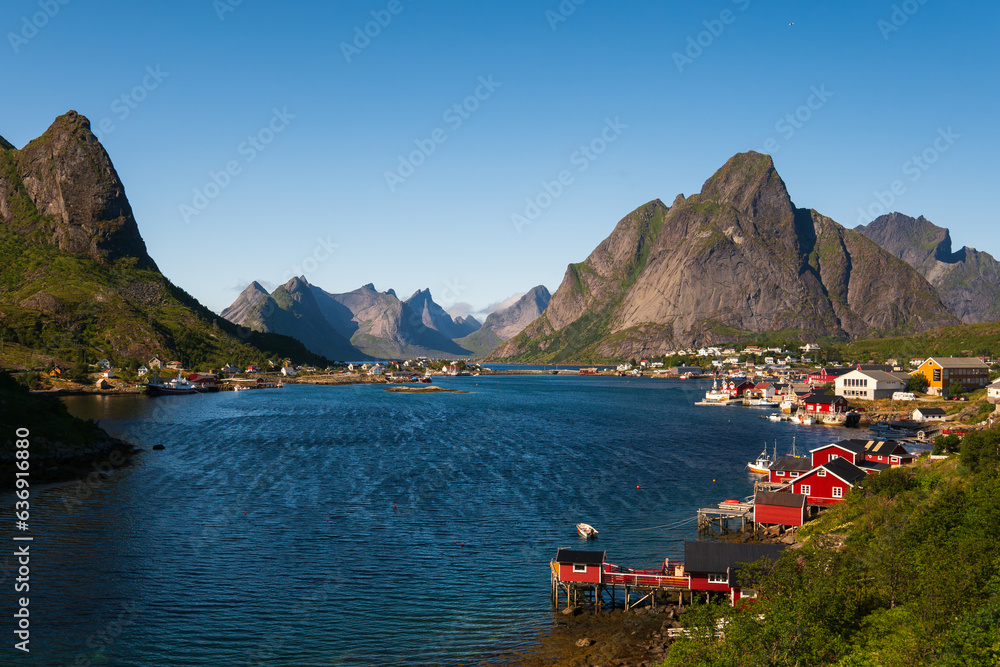 The fjord of Reine, Lofoten Islands, Norway, clear blue sky, high mountain peaks in the background.