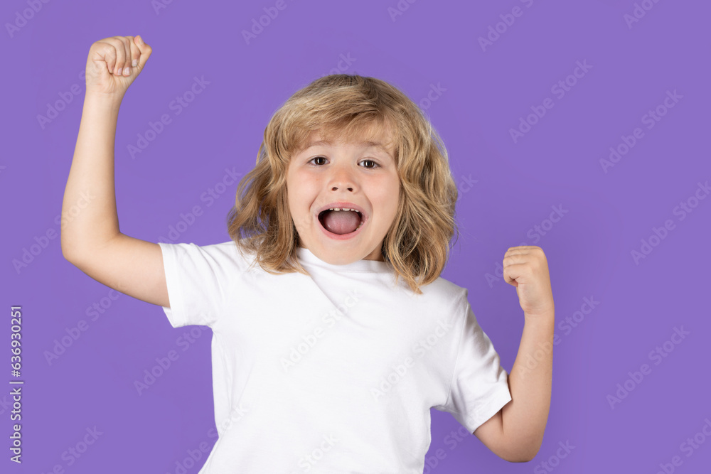 Excited kid boy celebrating victory on studio isolated background. Surprised kids face, amazed emotions of child. Rejoicing, yes gesture and success concept. Excited kid boy celebrating victory on studio isolated background. Surprised kids face, amazed emotions of child. Rejoicing, yes gesture and success concept.