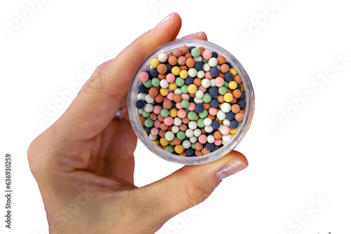 from mineral ceramics multi-colored balls, a hand holds a jar isolated on a white background, a bubble or spheres, source