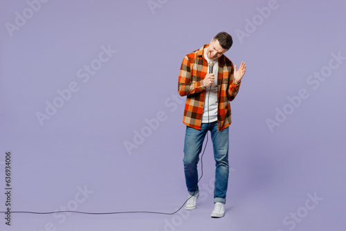 Full body young happy man wear checkered shirt white t-shirt casual clothes sing song in microphone at karaoke club isolated on plain pastel light purple background studio portrait. Lifestyle concept