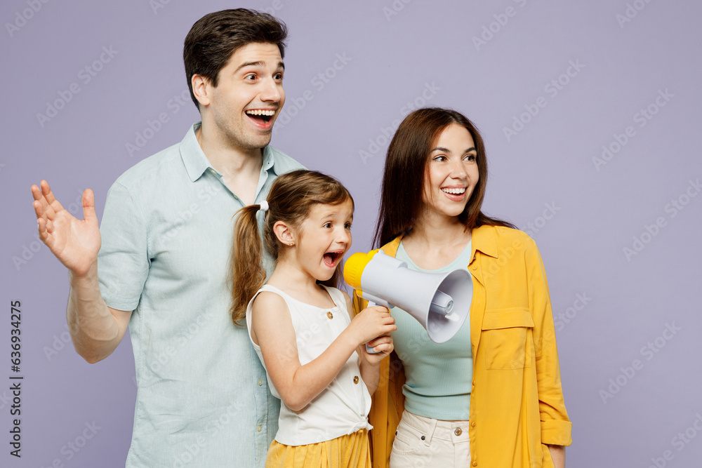 Young fun amazed parents mom dad with child kid girl 6 years old wear blue yellow casual clothes hold megaphone scream announces discounts sale Hurry up look aside isolated on plain purple background.