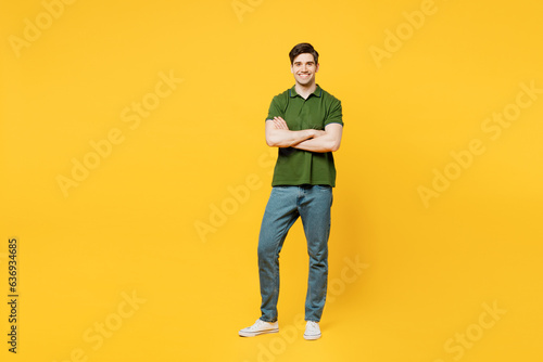 Full body young smiling cheerful satisfied happy man he wears green t-shirt casual clothes look camera hold hands crossed folded isolated on plain yellow background studio portrait. Lifestyle concept.