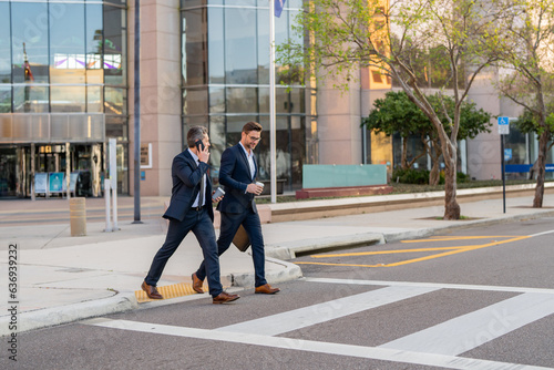 Businessmen go to work. Business taliking. Two businessmen in elegant business suits, walking and talking in city street. Colleagues and friends. Two cheerful business men walking outdoors. © Volodymyr