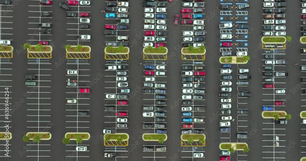 Aerial view of many cars parked on parking lot with lines and markings for parking places and directions. Place for vehicles in front of a grocery mall store Aerial view of many cars parked on parking lot with lines and markings for parking places and directions. Place for vehicles in front of a grocery mall store