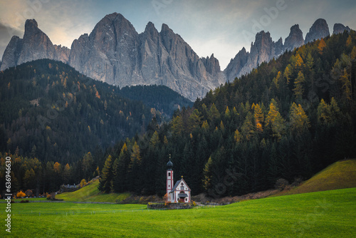 Autumn alpine scenery and small church on the green fields