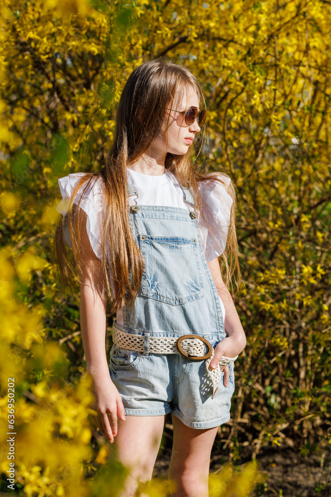 A little girl with blond long flowing hair and sunglasses on her head, in a denim overalls, white golfs and sneakers, a walk around the city with fountains A little girl with blond long flowing hair and sunglasses on her head, in a denim overalls, white golfs and sneakers, a walk around the city with fountains