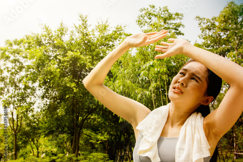 Canvas Print Asian woman doing sport jogging feeling sun and heat too hot during jogging in p