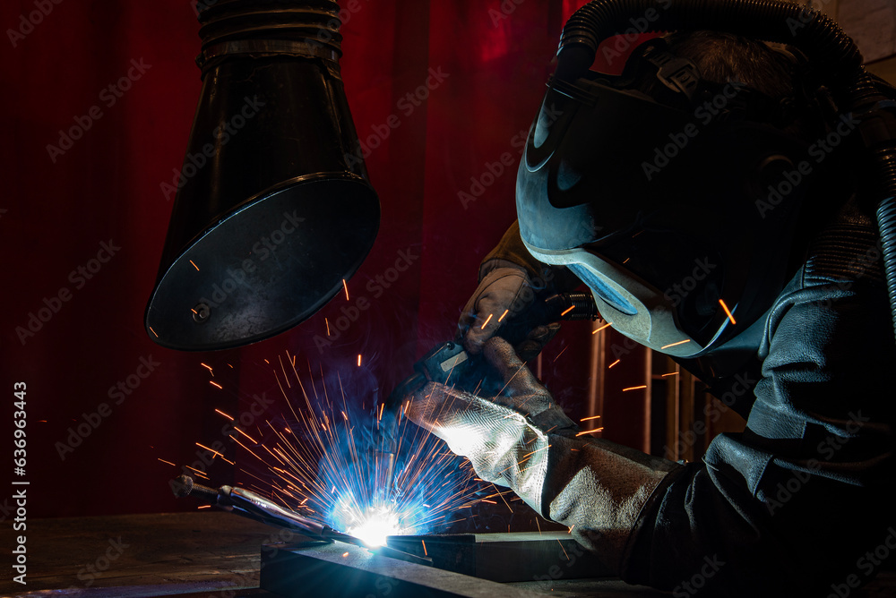 welder is welding metal part in car factory welder is welding metal part in car factory