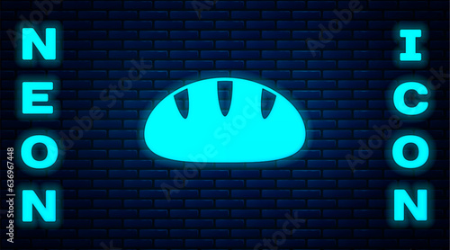 Glowing neon Christian bread icon isolated on brick wall background. Religion and Christianity. Vector