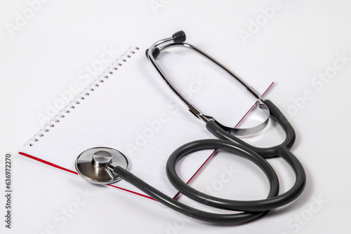 Doctor desk.Stethoscope and notebook on white background