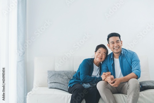 Happy Asian senior with smiling Asian man sitting sofa in living room ,Portrait Happy mother and son in living room ,Happiness family concept.