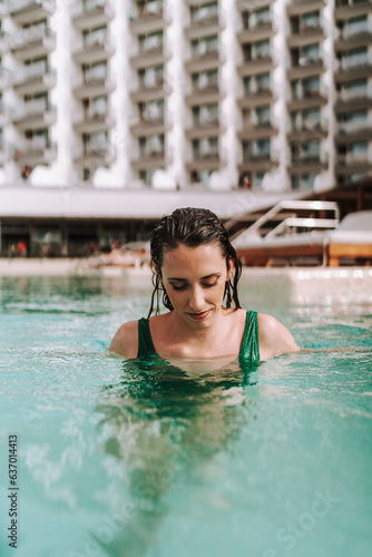 Chica joven delgada posando en piscina de hotel de vacaciones en traje de baño © MiguelAngelJunquera