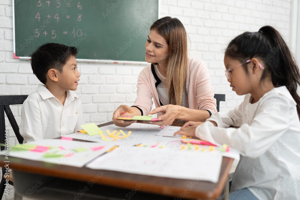 Teacher woman teaching children with paper and blackboard in class room