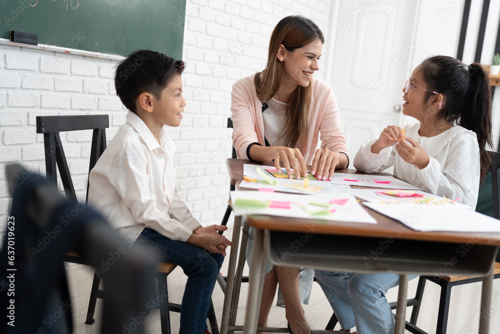 Teacher woman teaching children with paper and blackboard in class room Teacher woman teaching children with paper and blackboard in class room