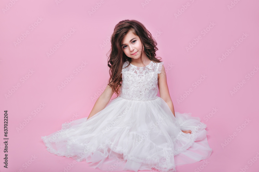 Beautiful little kid girl in white dress sitting on pink background. Happy birthday Beautiful little kid girl in white dress sitting on pink background. Happy birthday