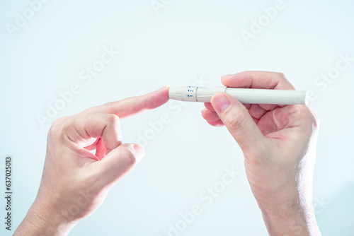 Close-up hand of pregnant woman hold sterile blood lancets and lancing device use fingertip venipuncture prepare for the next step to checking her blood sugar level with glucometer and at home, step 4