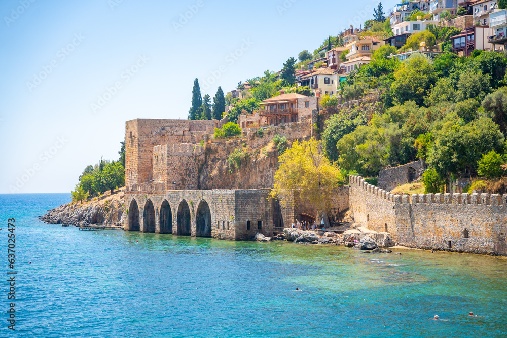 Ancient shipyard or Tersane near of Kizil Kule tower and beautiful beach and calm turquoise sea surface in Alanya, Turkey Ancient shipyard or Tersane near of Kizil Kule tower and beautiful beach and calm turquoise sea surface in Alanya, Turkey