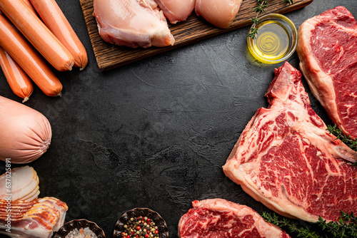 Variety of Fresh Raw meat and sausages on black background. Top view with space for your text