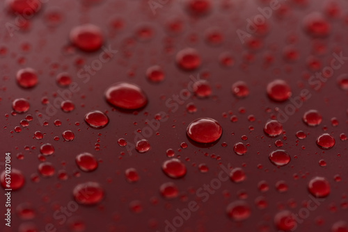 Fotografie Rain droplets on red sports car surface with hydrophobic treatment